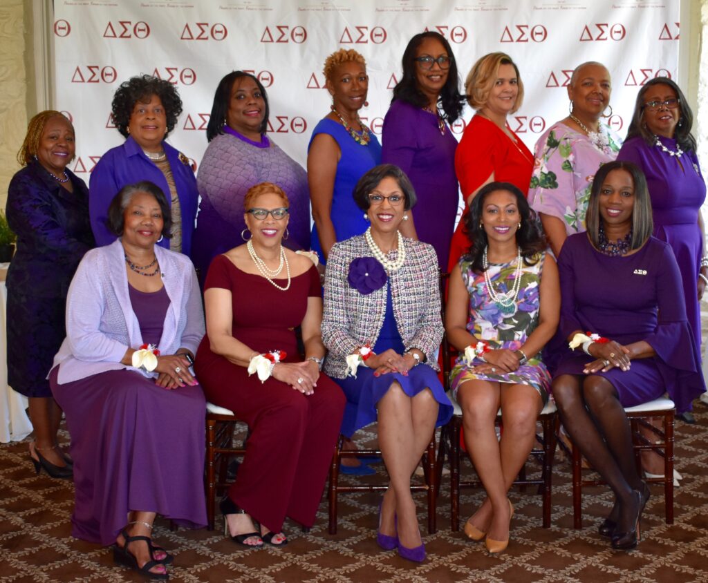 A group of women posing together at a formal event, some holding awards.