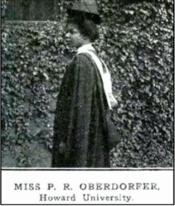 Black and white photo of a woman in academic gown standing sideways.