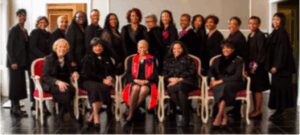 A group portrait of professionally dressed women on stage.