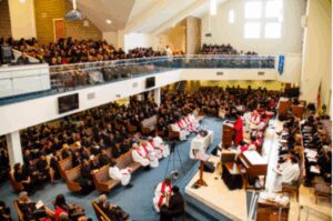 A large congregation attending a church service with choir and clergy.