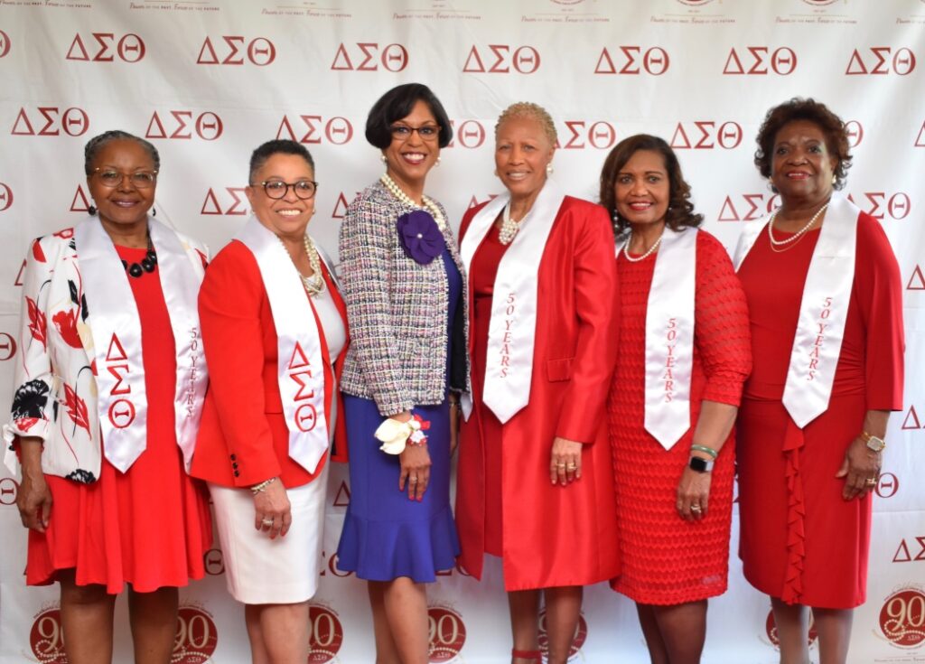 Six women in red and white dresses posing at a Delta Sigma Theta event.