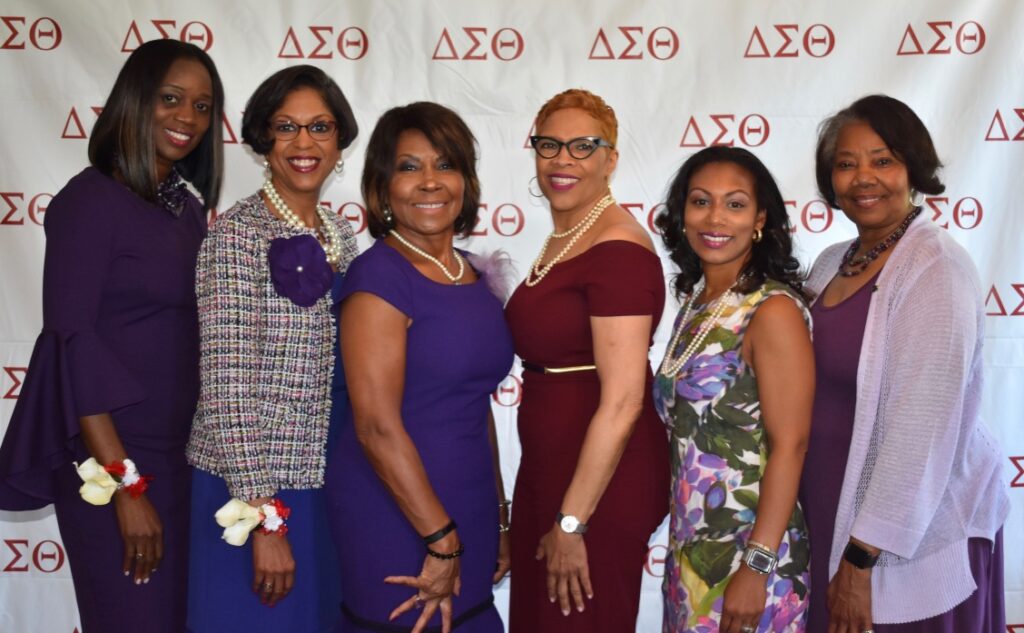 Four women posing together at a Delta Sigma Theta event.