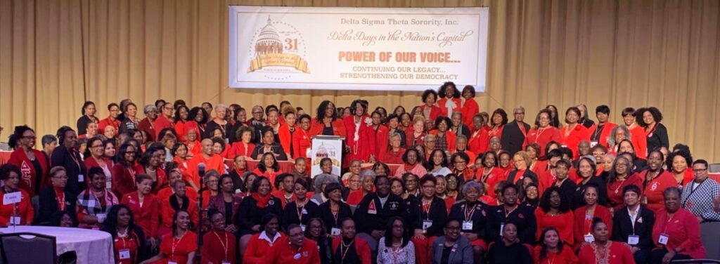 Large group photo of women in red at a celebratory event honoring African American women leaders.