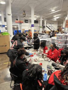 A group of people assembling items in a large indoor space.