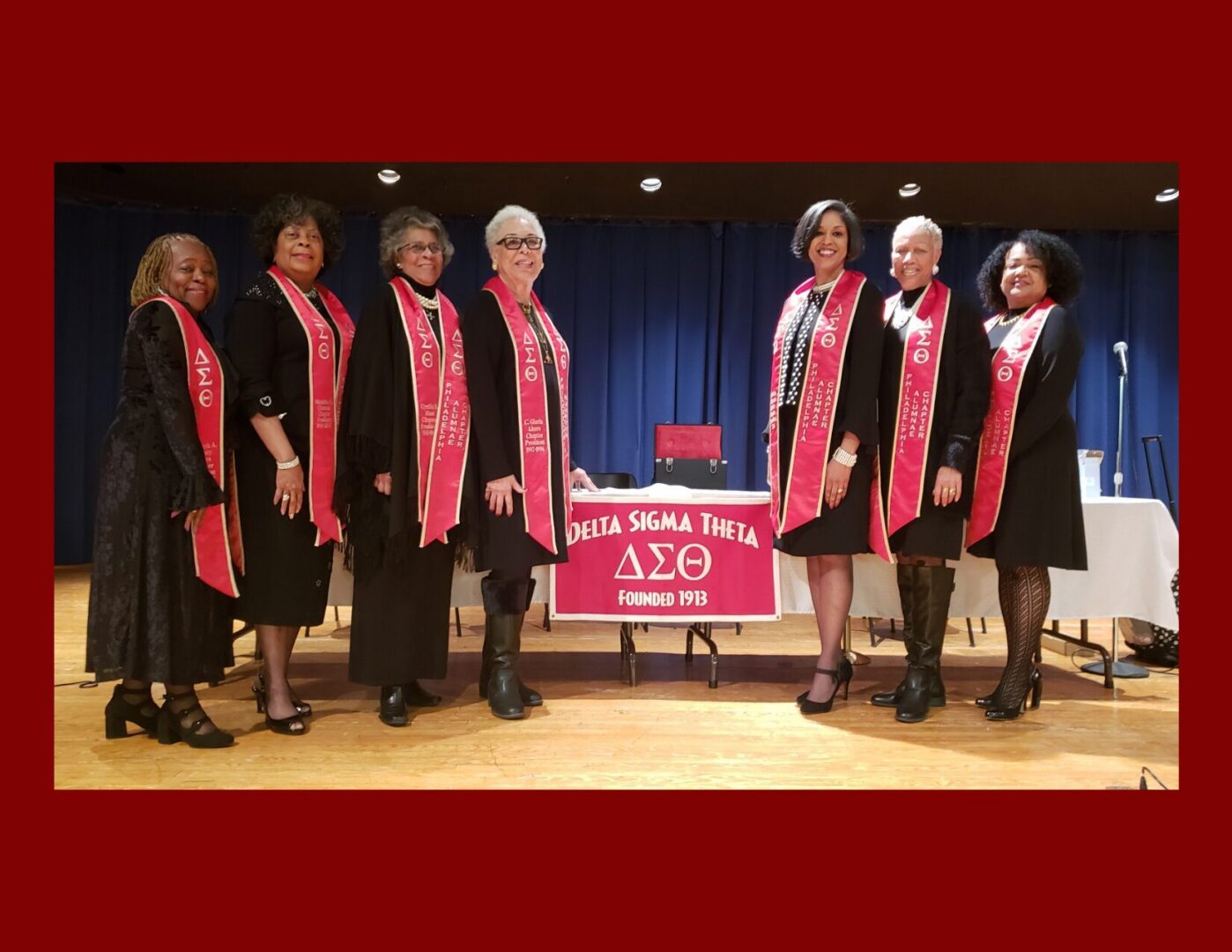 Sorority members in red stoles on stage