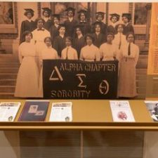 Group photo of Alpha Chapter Sigma Sorority members with their banner.