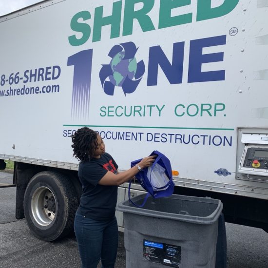 Woman shredding documents at a secure shredding truck.
