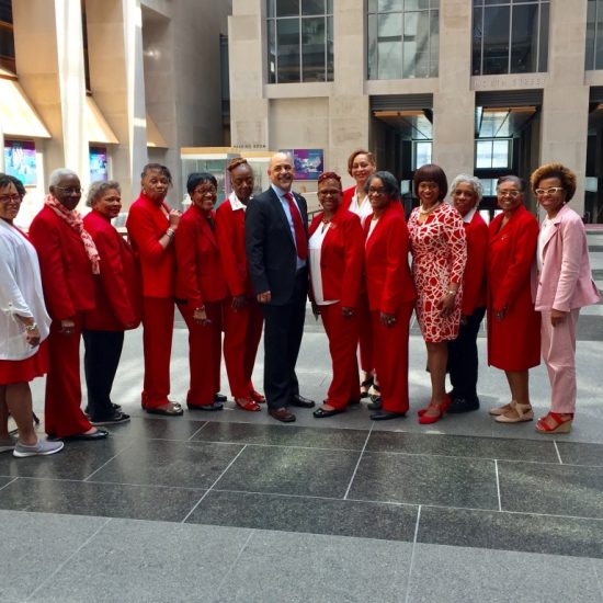 Group of professionals dressed in red and pink standing outdoors.