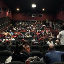 Large audience listening to a speaker in cinema