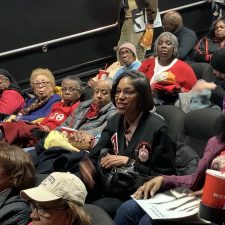 Group of diverse women seated at an event, engaging and smiling.