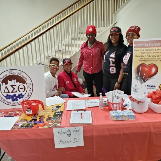A group of people at a heart health awareness booth with informational materials.