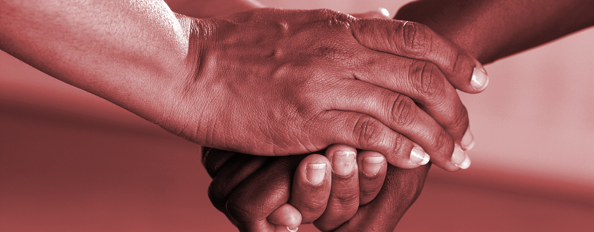 Two hands clasped together in a gesture of support and care.